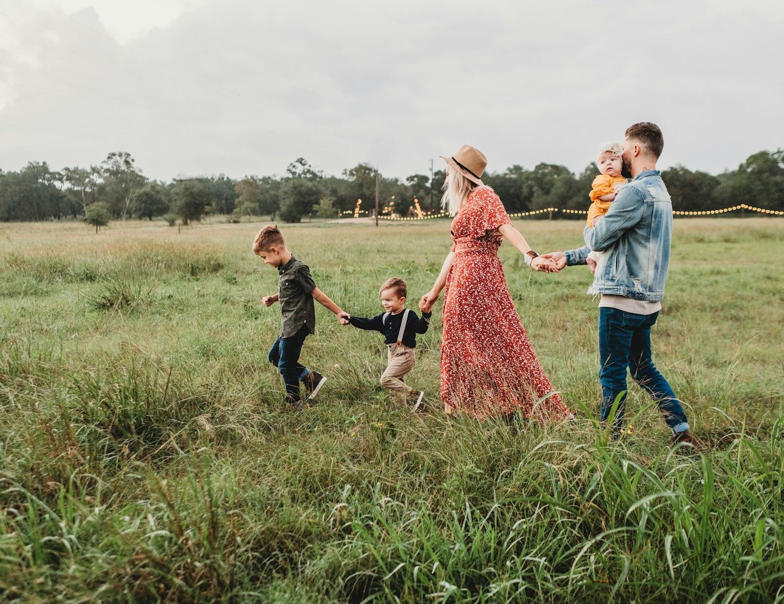 A family walking hand in hand through a meadow
