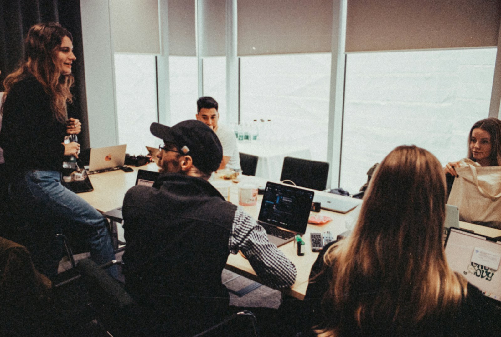 A team seated around a table with laptops during a working session
